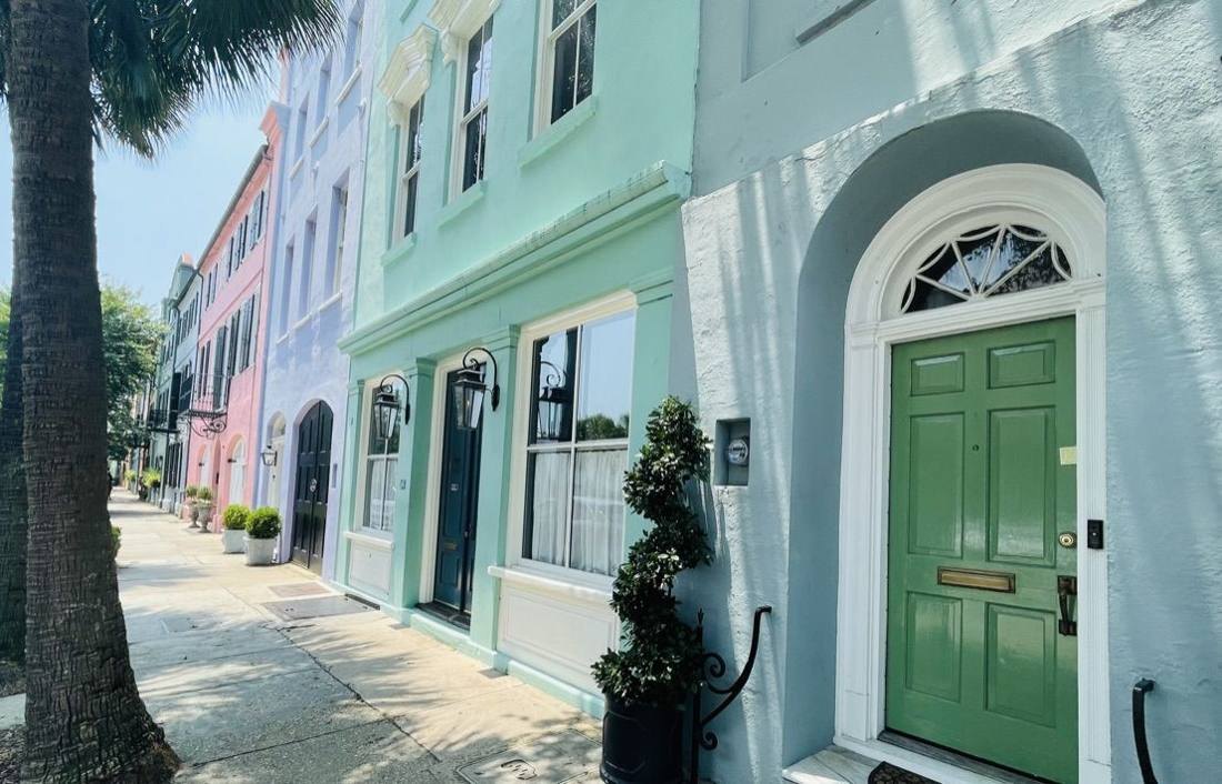 Green front door on a pastel Charleston row house