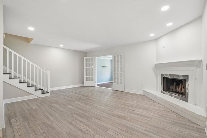 Living room with fireplace, stairs and French doors to the sunroom