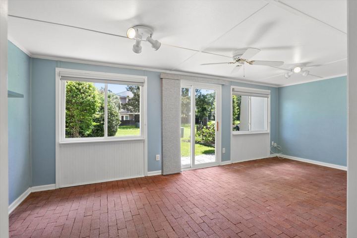 Enclosed sunroom with brick floor and doors to the yard